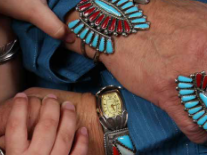 Hands reaching out to other hands paired with turquoise jewelry