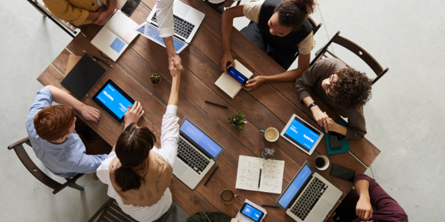 A group of people on laptops at a table