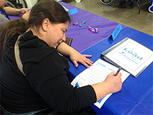 A woman signs a document