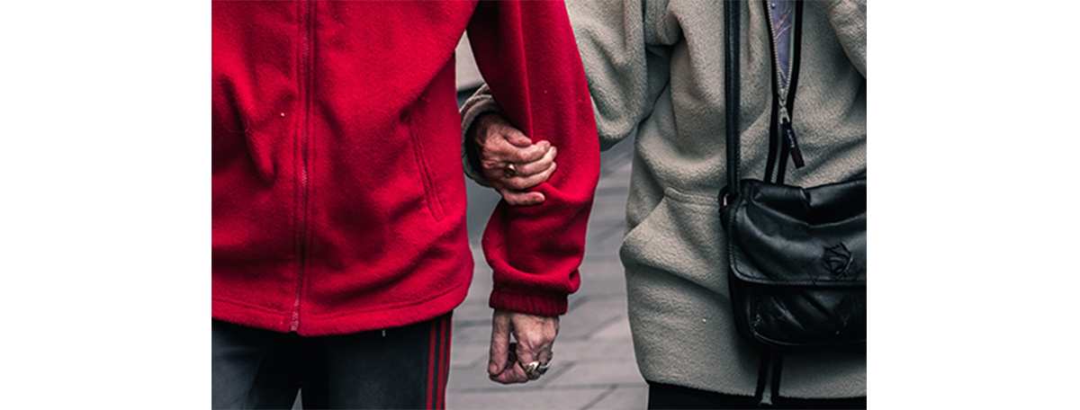 Older man and woman holding arms