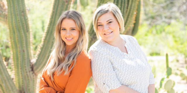 Two women smile at the camera